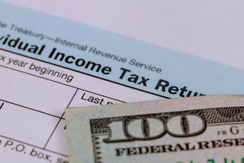 Stimulus economic tax return 1040 form and US 100 dollar bills currency